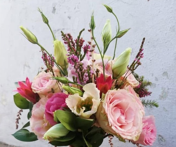 Bridal bouquet of pink roses, fresh greenery and delicate purple flowers