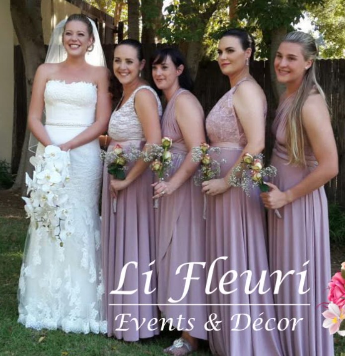 Bride with a cascading white bouquet beside bridesmaids in lilac dresses