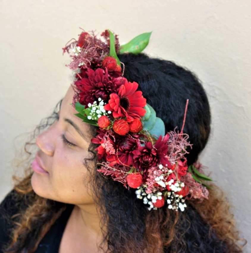 Fresh red flower crown with small white flowers and green leaves