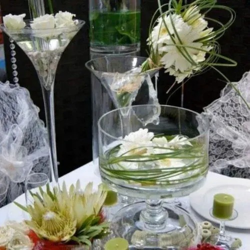 Glass centrepiece with a protea, white flowers and looped grasses